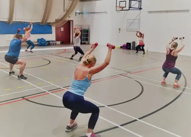 Group of women taking a fitness class in a sports hall