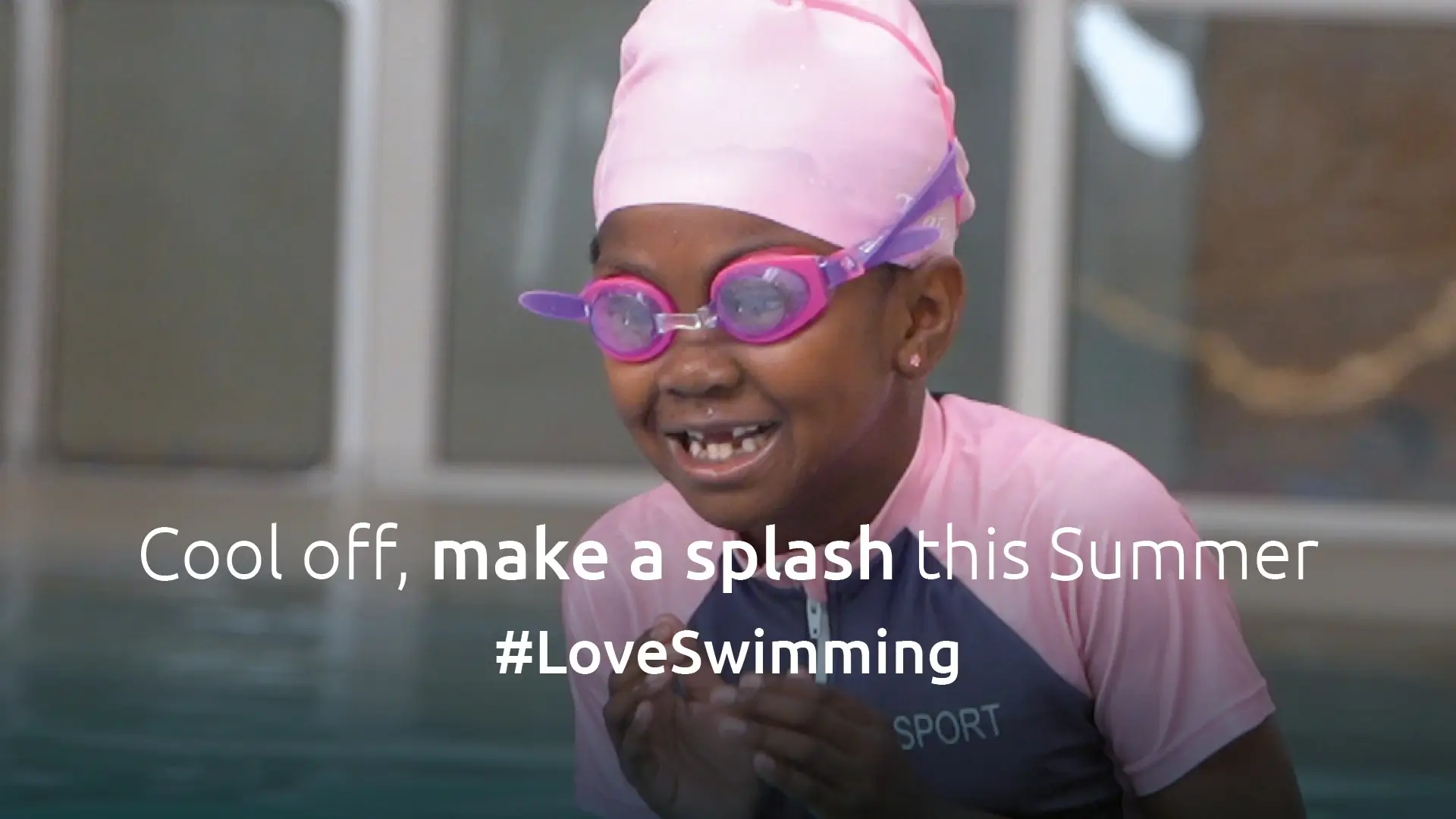 Girl in pink swim cap in swimming pool