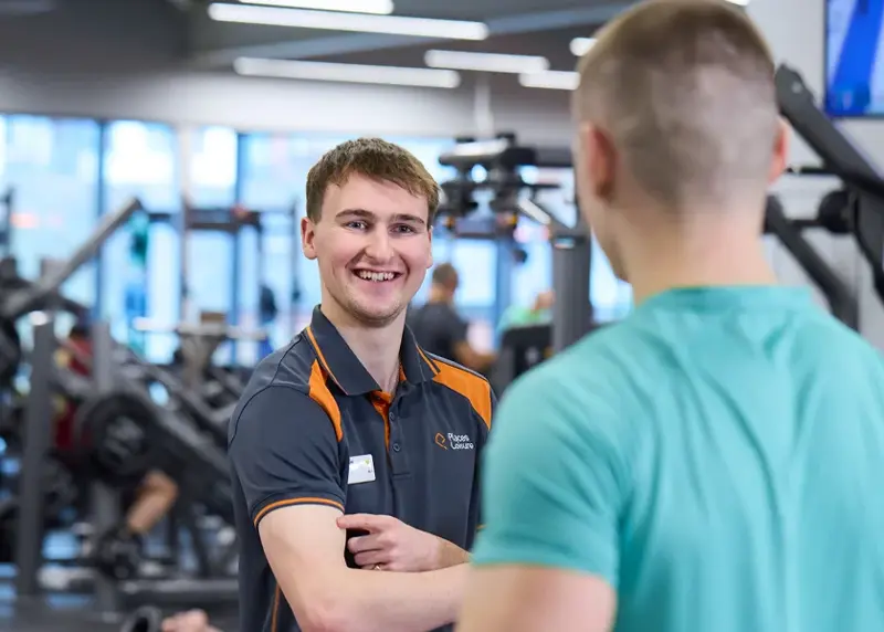 Three fitness instructors talking in a gym
