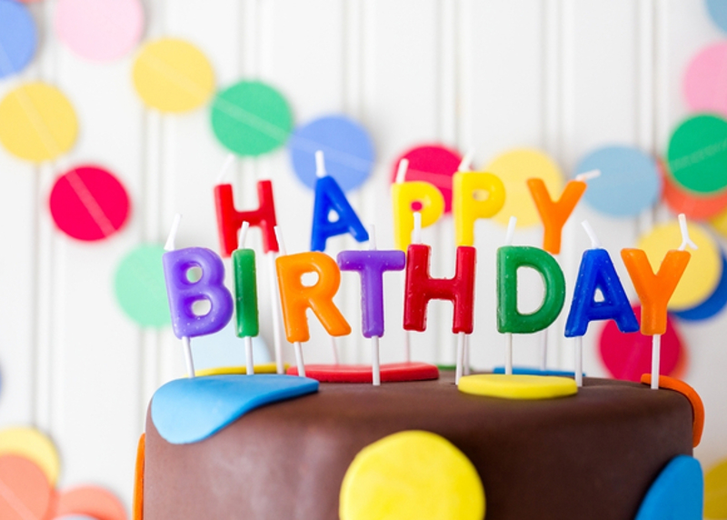 Candles spelling out Happy Birthday on top of cake