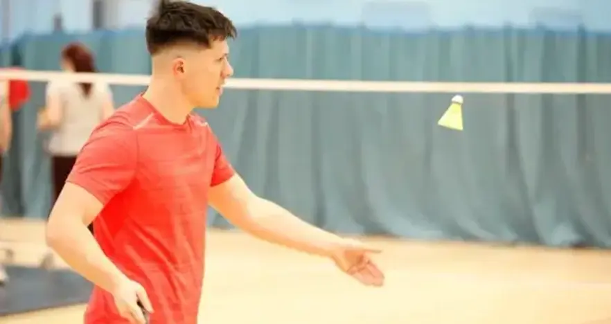 Man serving in badminton match