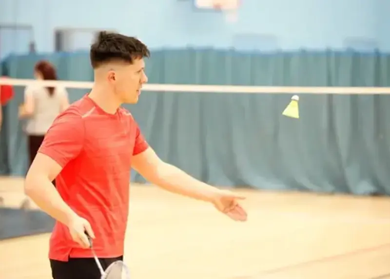 Man serving in badminton match