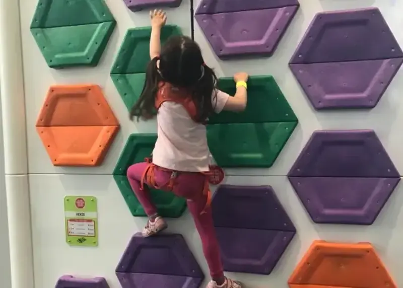 Young girl climbing clip n climb wall at Andover Leisure Centre