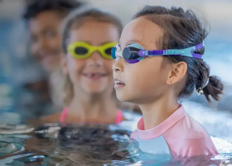 Group of children in googles in swimming pool