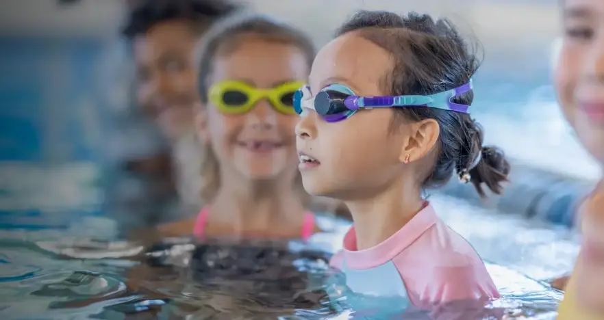 Group of children in googles in swimming pool
