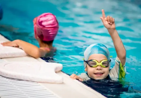 Child in a swim cap smiling in pool