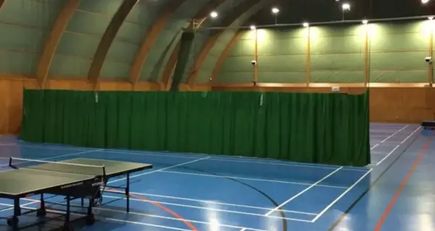 Table tennis tables in a sports hall with blue floor